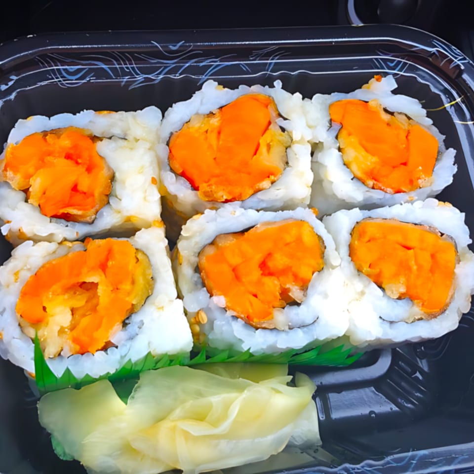 Six pieces of Big Bang Sushi & Poke's sweet potato sushi rolls with pickled ginger in a black container.