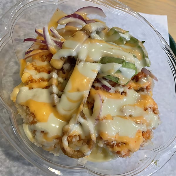 Big Bang Sushi & Poke's poke bowl with fried tempura, avocado, red onions, and two sauces.